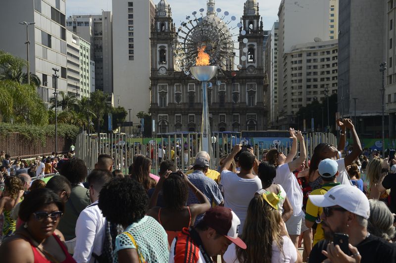 Pessoas observam a Pira Olímpica instalada no Boulevard Olímpico no Porto do Rio